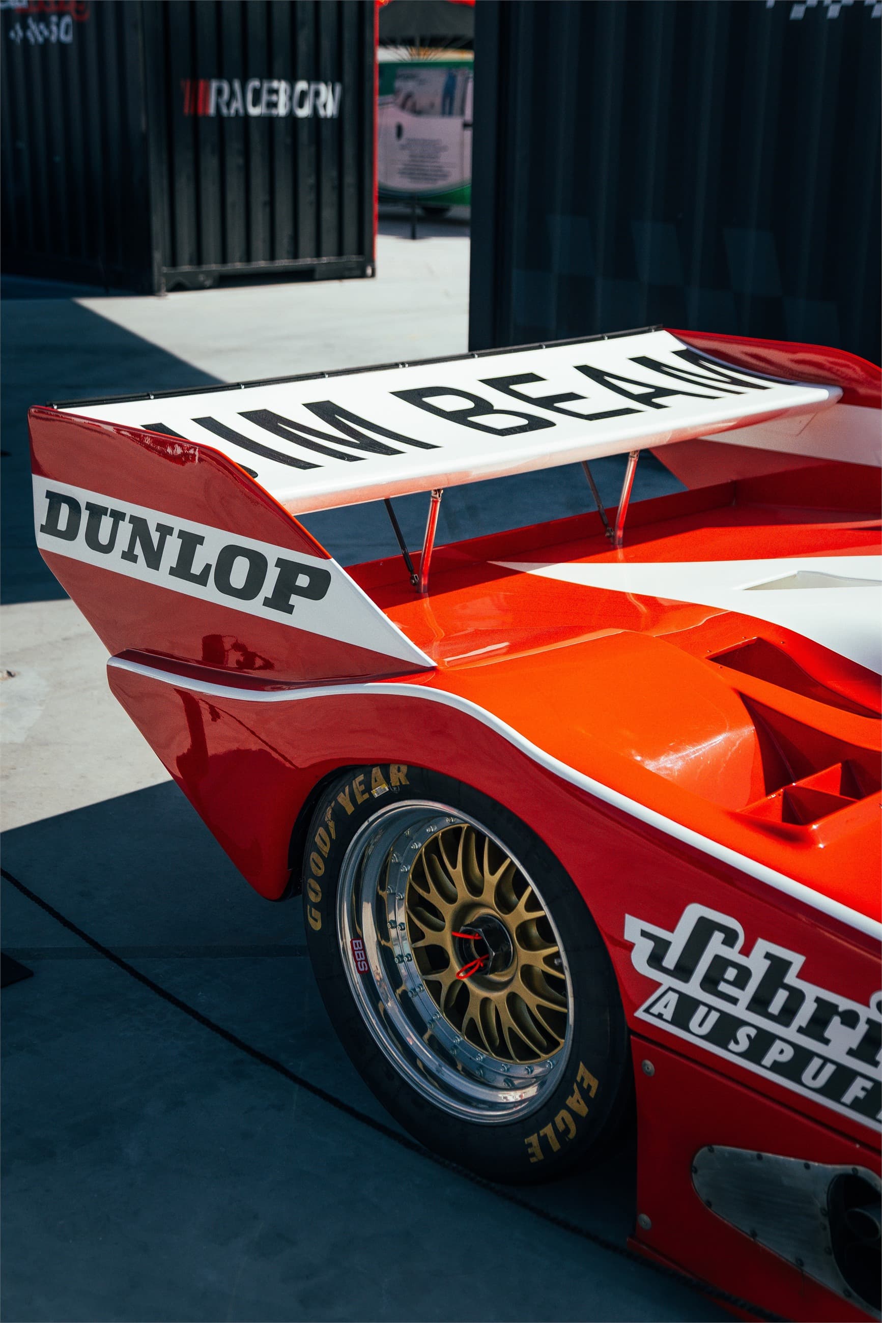 Detail photograph of a red race car body and rear wing.